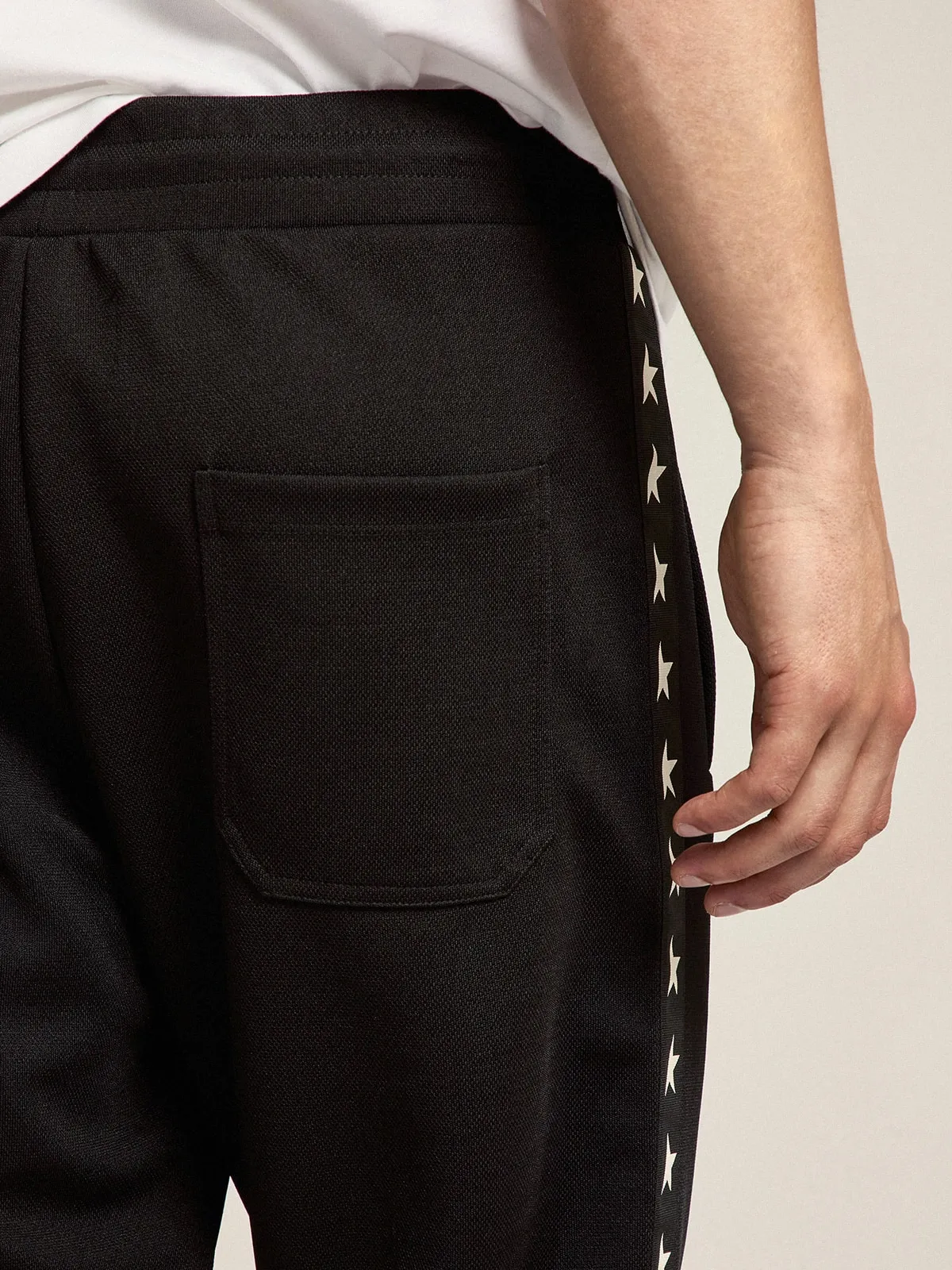 Men's black joggers with white stars on the sides